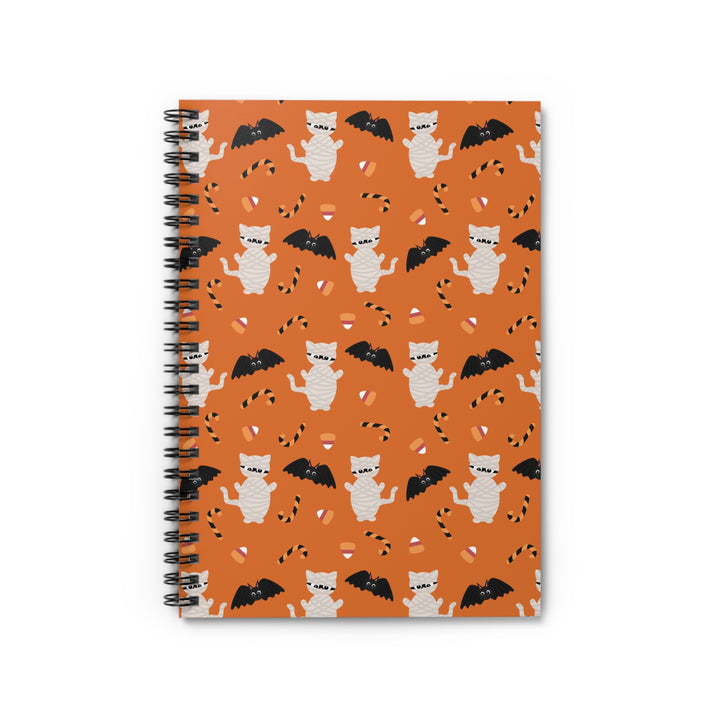 Notebook with Halloween-themed design featuring cats and bats on an orange background