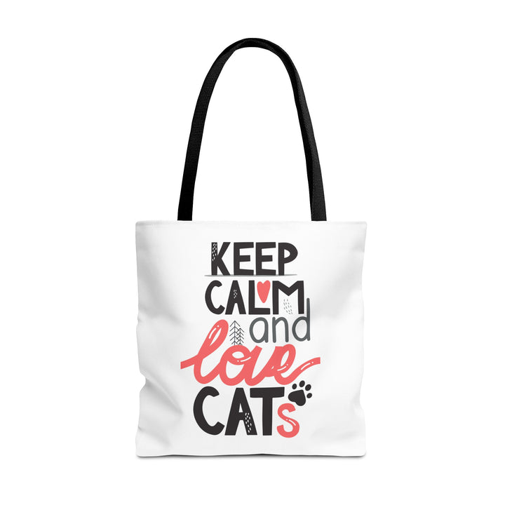 A white canvas tote bag with black handles, featuring a printed graphic that reads 'KEEP CALM and love CATS' in black and coral pink lettering, on a solid white background.