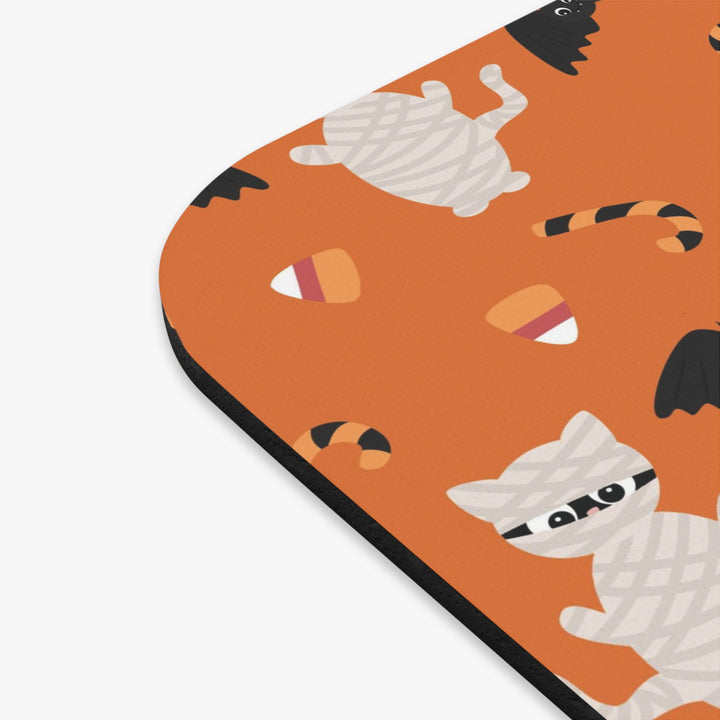 Halloween-themed mouse pad with ghost and candy design on an orange background