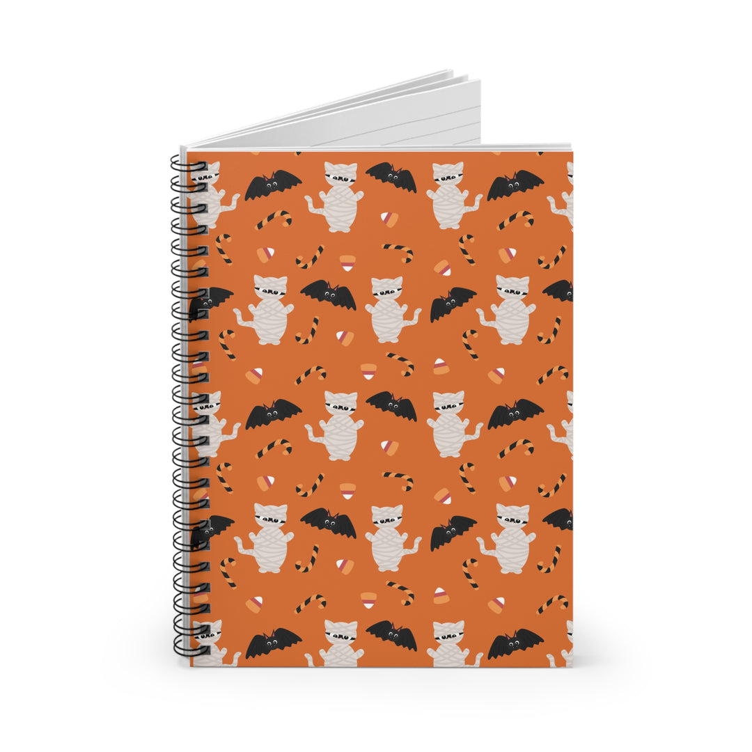 Notebook with Halloween-themed cover featuring cats and bats on an orange background