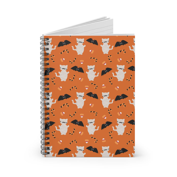Notebook with Halloween-themed cover featuring cats and bats on an orange background