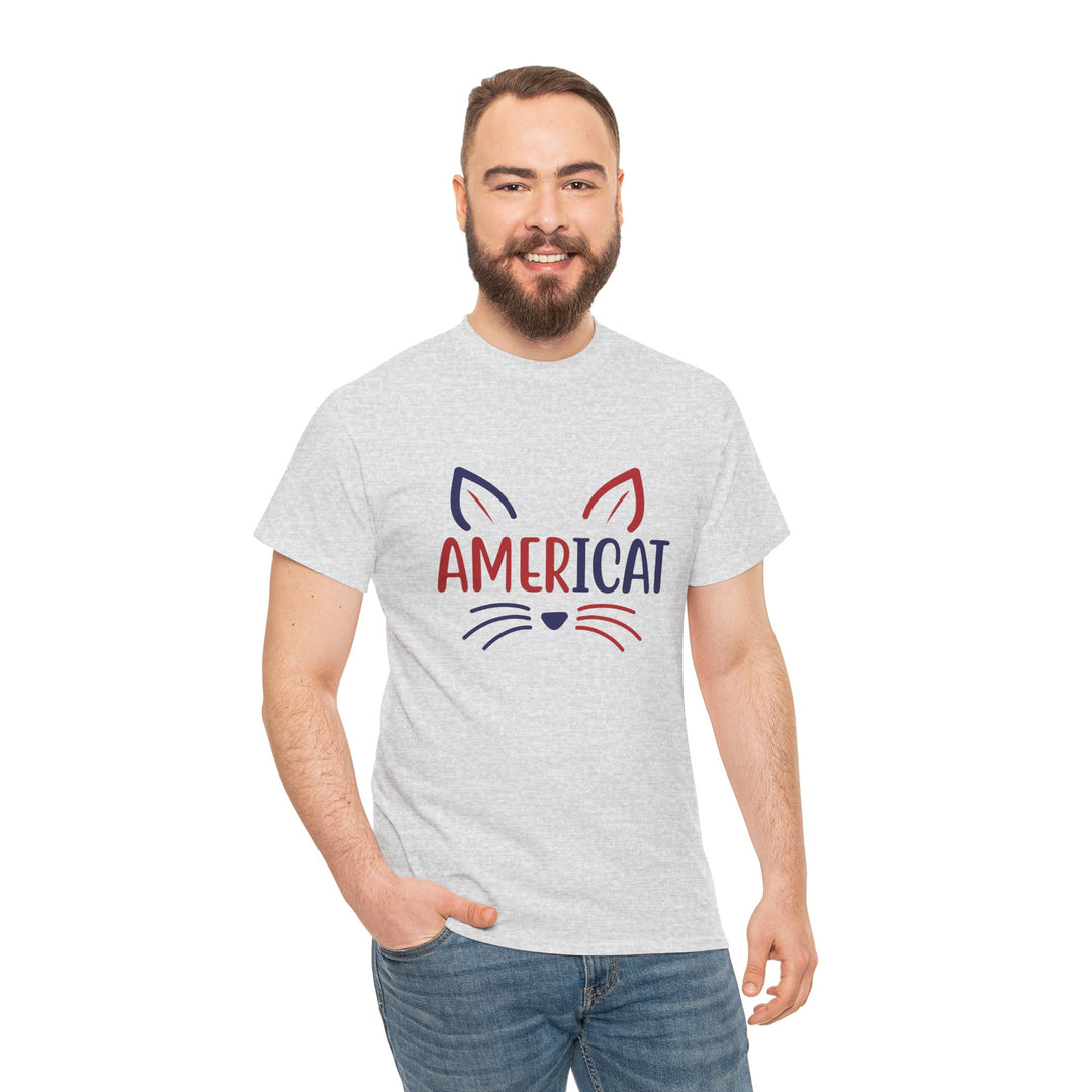 A man wearing a light heather gray t-shirt with a red and navy graphic of a cat's face and the word 'AMERICAT' printed on the chest, paired with blue jeans, against a plain white background.
