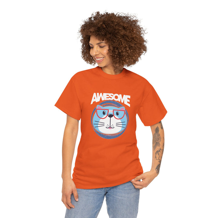 A woman with curly brown hair wearing a bright orange graphic t-shirt with a cartoon cat wearing glasses and the word 'AWESOME' above it, paired with light blue jeans, against a plain white background.