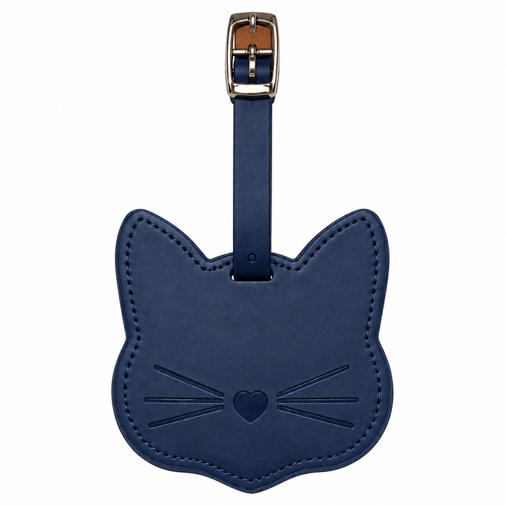 A navy blue leather luggage tag shaped like a cat's head, featuring an embossed face with whiskers and a heart, attached to a matching strap with a silver metal buckle.
