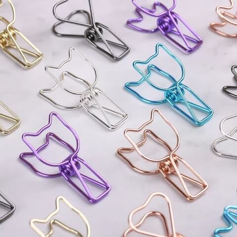 Colorful cat-shaped paper clips on a light background