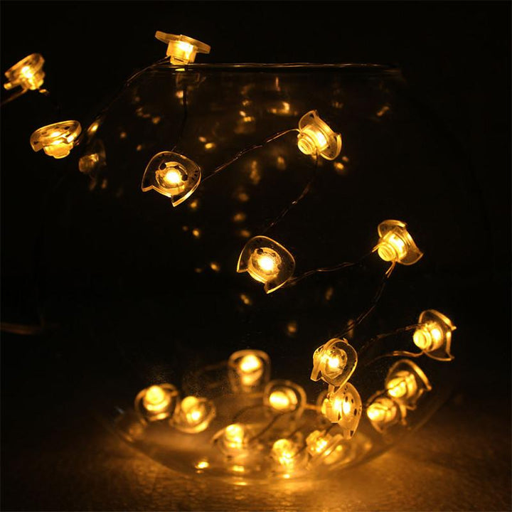 String of small, illuminated lights shaped like cat heads on a dark background