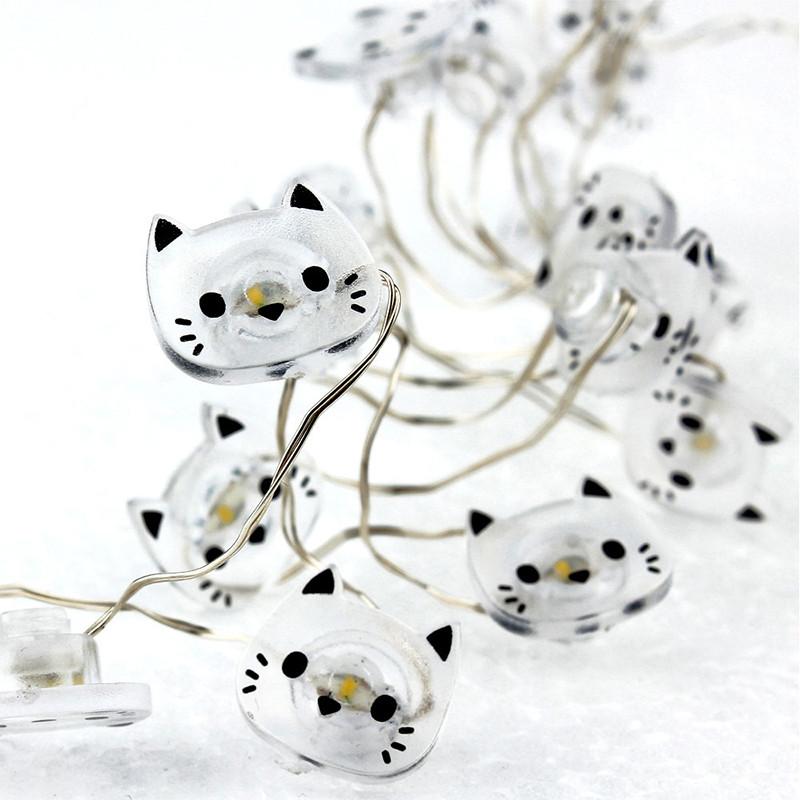 String lights shaped like white cats with black accents on a white background